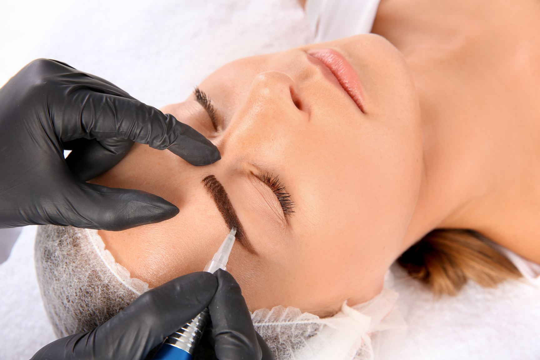 Young Woman Undergoing Eyebrow Correction Procedure in Salon